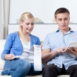 Married couple calculates the expenses sitting on the sofa