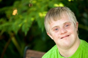 Portrait of cute handicapped boy in garden.